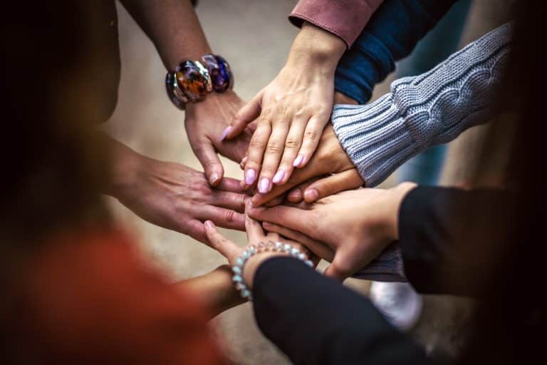 Mains superposées en signe de soutien et de lien