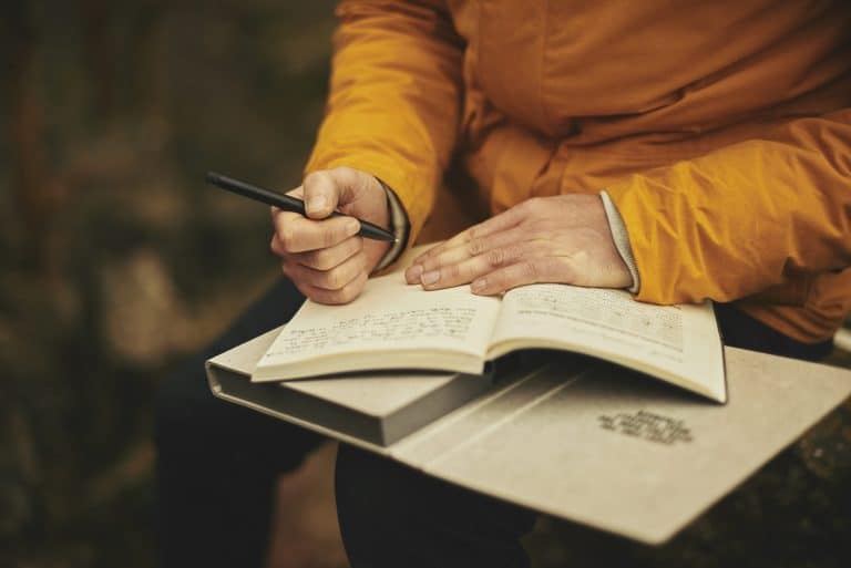 Mains écrivant dans un carnet, pratique du journal de gratitude